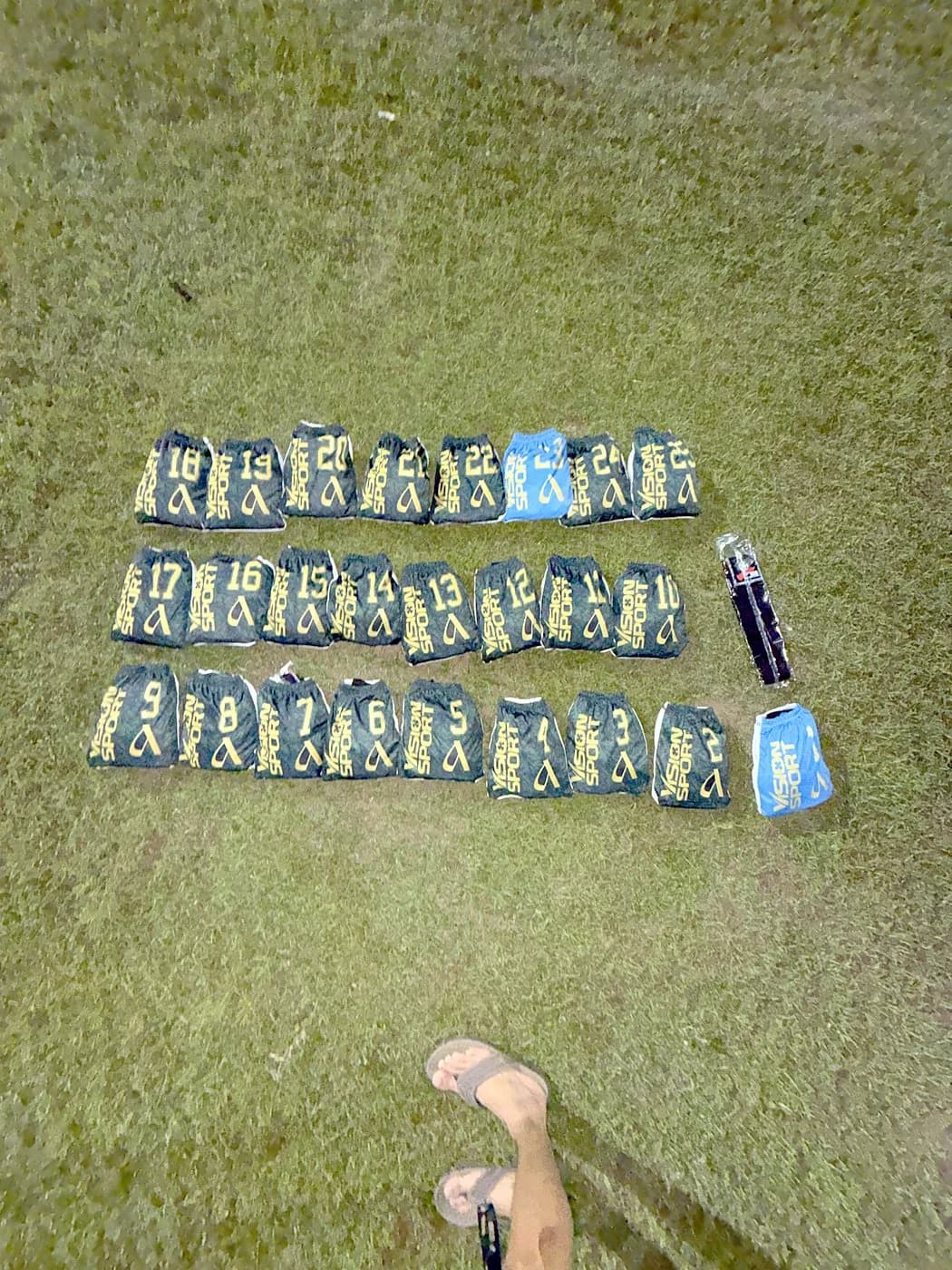 Numbered Arcadia soccer uniforms laid out on the grass